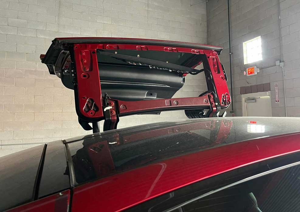 Raised Tesla Model X falcon-wing door frame during door-glass service