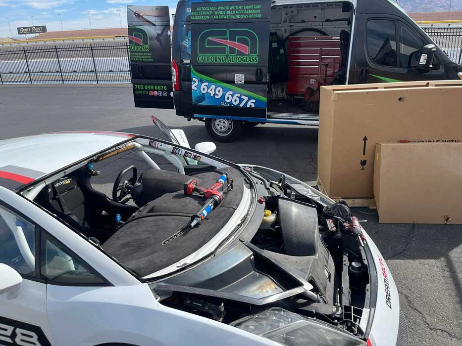 Vehicle windshield opening beside a Las Vegas mobile service van and glass crates